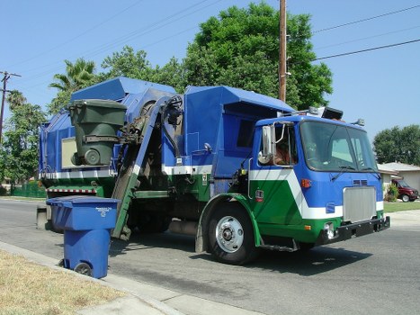 Low-emission electric van loading reclaimed office furniture in a neighbourhood